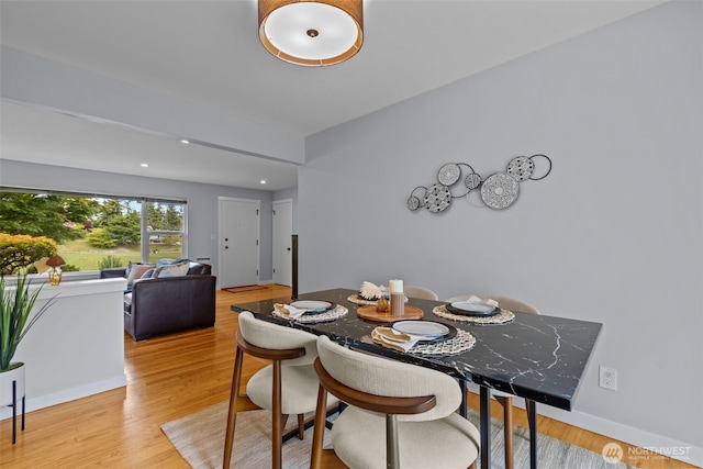 dining area featuring light wood finished floors, baseboards, and recessed lighting
