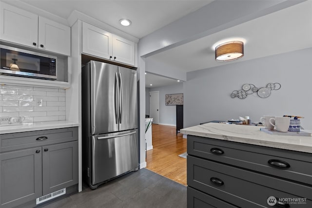 kitchen featuring appliances with stainless steel finishes, gray cabinetry, backsplash, white cabinets, and recessed lighting