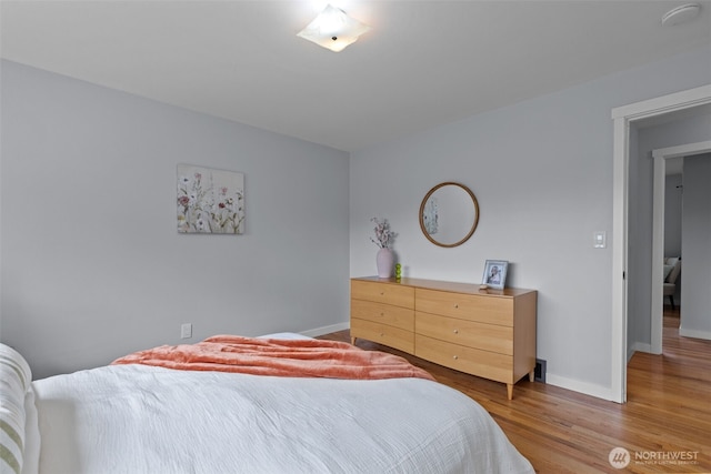 bedroom featuring baseboards and light wood-style floors