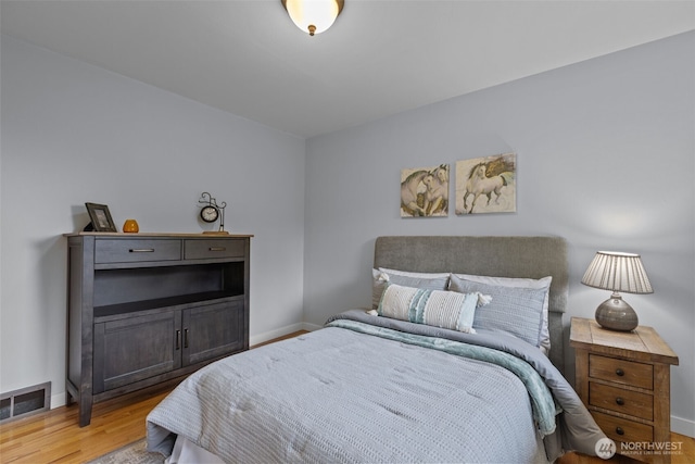 bedroom with light wood finished floors and baseboards