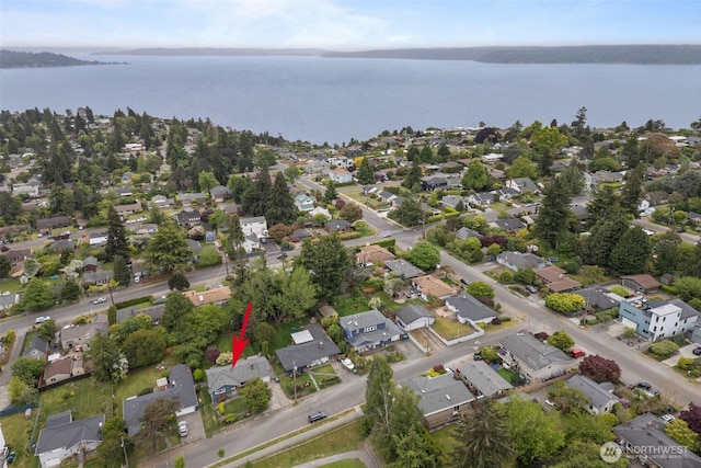 aerial view of property and surrounding area featuring a nearby body of water and nearby suburban area
