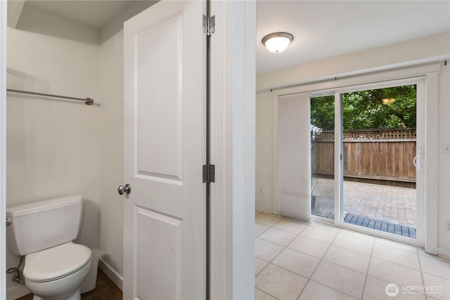 bathroom with toilet, baseboards, and tile patterned floors