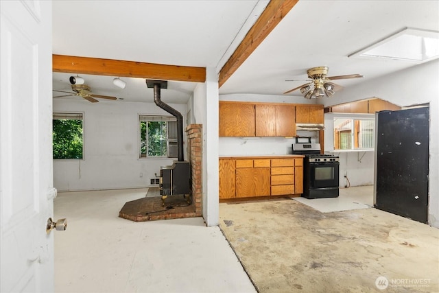 44119 Fir Rd, Gold Bar, WA 98251 - kitchen featuring black gas range oven, a wood stove, ceiling fan, concrete floors, and brown cabinetry