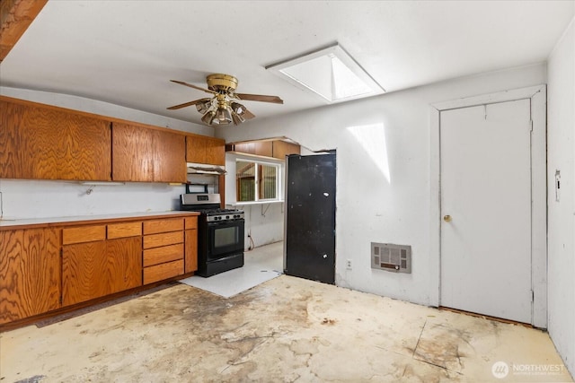 44119 Fir Rd, Gold Bar, WA 98251 - kitchen featuring gas range oven, under cabinet range hood, brown cabinets, and a skylight