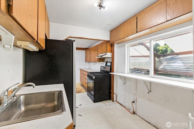 44119 Fir Rd, Gold Bar, WA 98251 - kitchen featuring gas range, under cabinet range hood, brown cabinetry, concrete floors, and light countertops