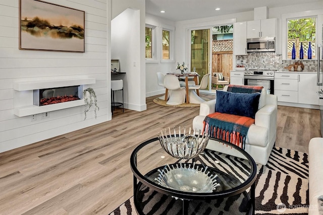 7350 21st Ave NW, Seattle, WA 98117 - living area featuring a glass covered fireplace, light wood-style floors, and recessed lighting