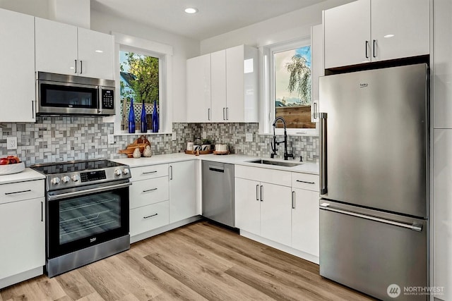 7350 21st Ave NW, Seattle, WA 98117 - kitchen featuring stainless steel appliances, light countertops, white cabinets, and recessed lighting