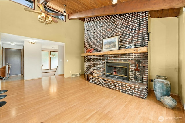 10410 260th St E, Graham, WA 98338 - unfurnished living room featuring wooden ceiling, a fireplace, beam ceiling, a chandelier, and wood finished floors