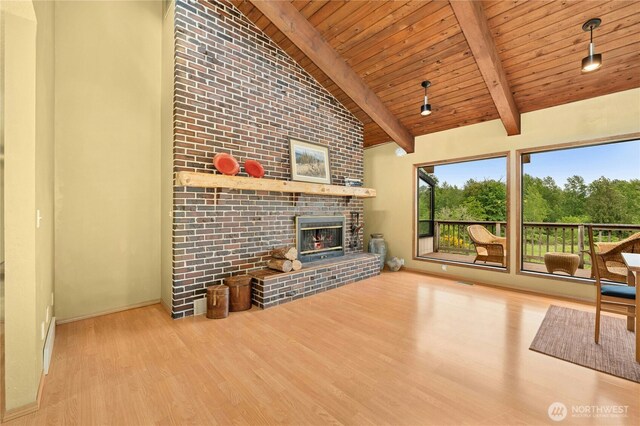 10410 260th St E, Graham, WA 98338 - unfurnished living room featuring wooden ceiling, wood finished floors, a fireplace, baseboards, and beamed ceiling