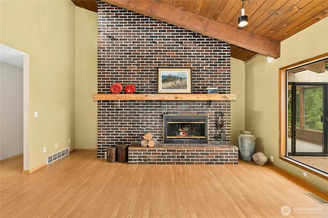 10410 260th St E, Graham, WA 98338 - unfurnished living room with wood finished floors, beamed ceiling, baseboards, a fireplace, and wooden ceiling
