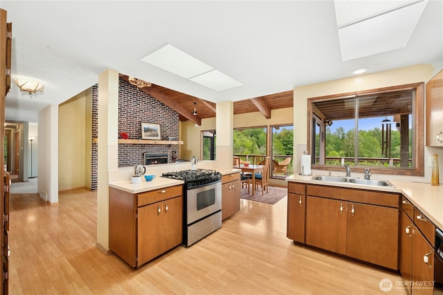 10410 260th St E, Graham, WA 98338 - kitchen featuring gas range, a sink, a skylight, and light countertops