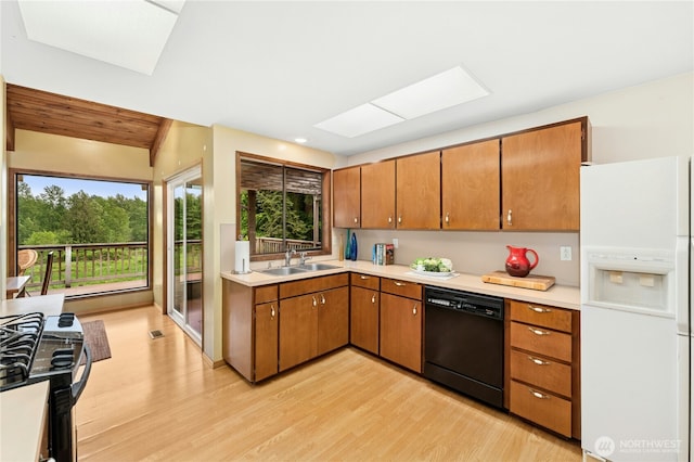 10410 260th St E, Graham, WA 98338 - kitchen featuring white fridge with ice dispenser, black dishwasher, a sink, and light wood-style floors