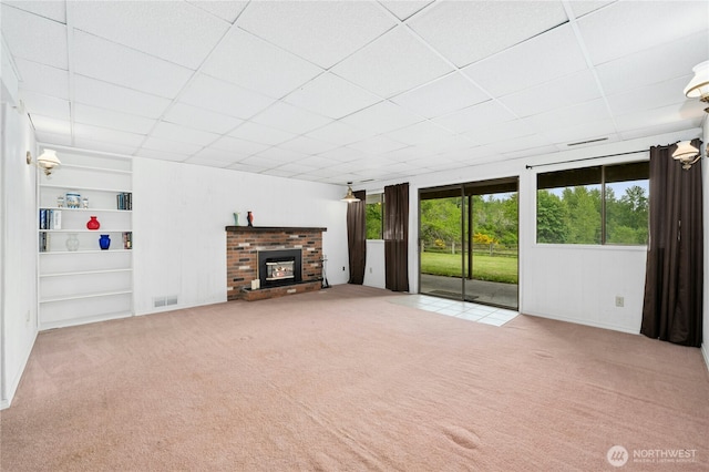 10410 260th St E, Graham, WA 98338 - unfurnished living room featuring a drop ceiling, carpet floors, a brick fireplace, and built in features