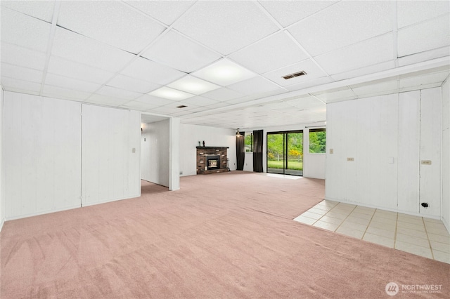 10410 260th St E, Graham, WA 98338 - unfurnished living room featuring light carpet, a paneled ceiling, and a glass covered fireplace