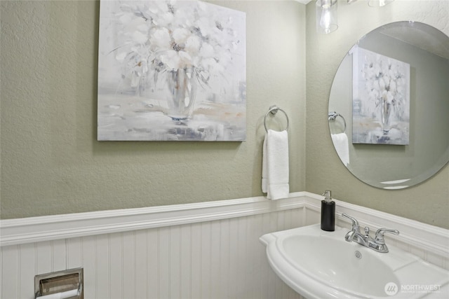 260 Newport Way NW Unit C24, Issaquah, WA 98027 - bathroom with a sink, a textured wall, and wainscoting