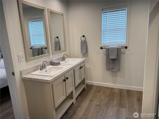 702 Bryce Pl SW, Mattawa, WA 99349 - ensuite bathroom with baseboards, wood finished floors, double vanity, and plenty of natural light