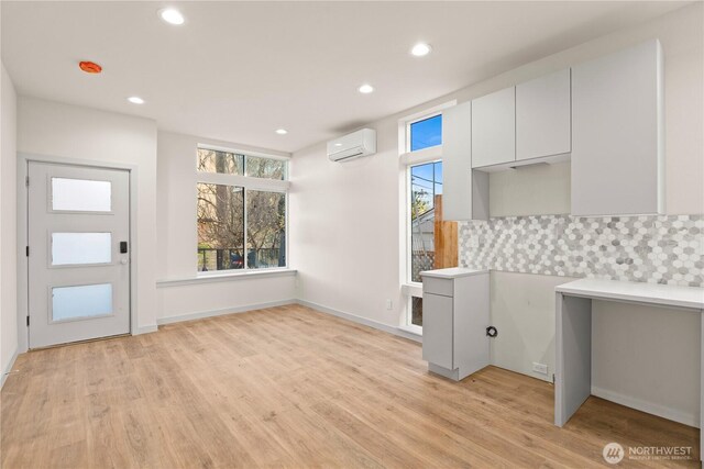 5517A 9th Ave NW, Seattle, WA 98107 - kitchen featuring an AC wall unit, backsplash, light wood-type flooring, recessed lighting, and light countertops