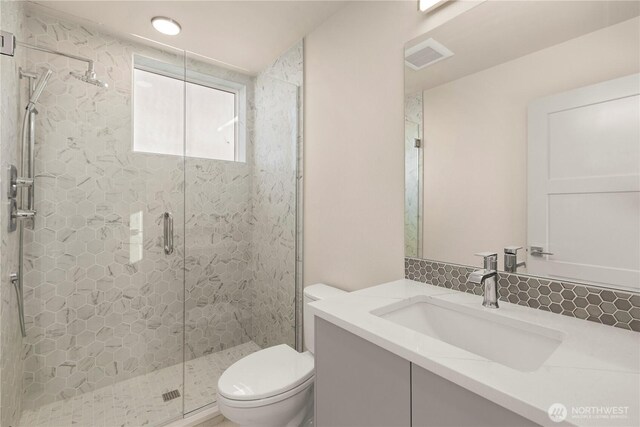 5517A 9th Ave NW, Seattle, WA 98107 - full bathroom with toilet, a shower stall, vanity, and decorative backsplash