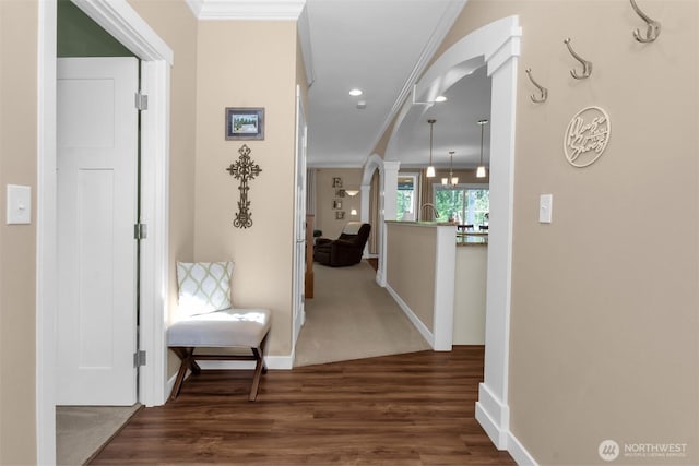 hall featuring ornamental molding, wood finished floors, baseboards, arched walkways, and recessed lighting