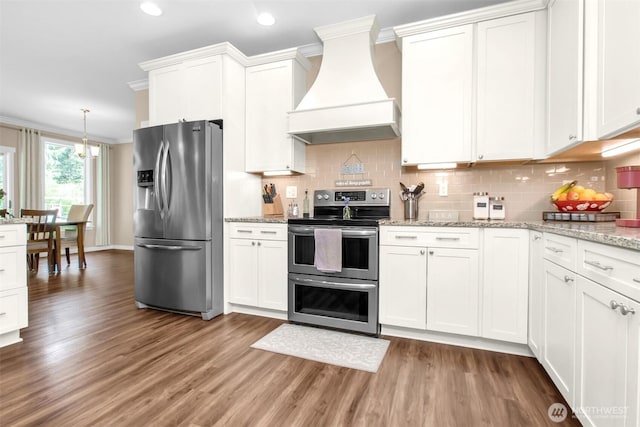 kitchen with stainless steel appliances, custom range hood, light wood-style flooring, ornamental molding, and decorative backsplash
