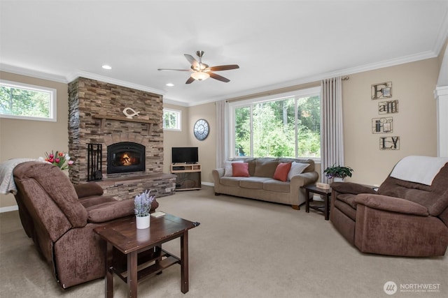 carpeted living room with a ceiling fan, healthy amount of natural light, a fireplace, ornamental molding, and baseboards