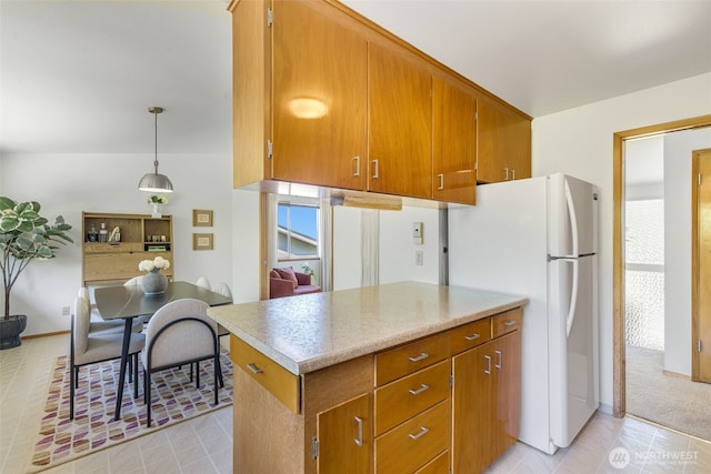4839 S Mead St, Seattle, WA 98118 - kitchen featuring freestanding refrigerator, brown cabinetry, and light countertops