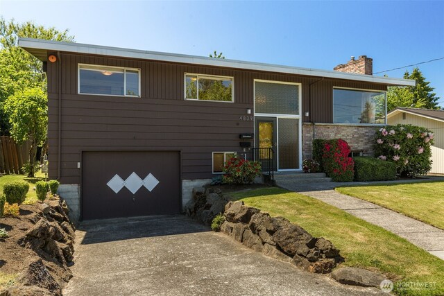 4839 S Mead St, Seattle, WA 98118 - view of front of property featuring concrete driveway, an attached garage, and a chimney