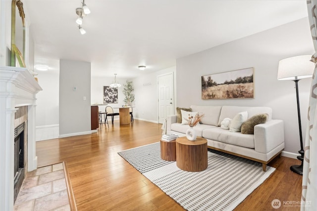 13209 Newcastle Way Unit A308, Newcastle, WA 98059 - living room featuring light wood finished floors, a chandelier, baseboards, and a fireplace
