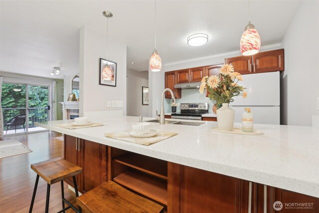 13209 Newcastle Way Unit A308, Newcastle, WA 98059 - kitchen featuring stainless steel electric range oven, a sink, under cabinet range hood, light stone counters, and pendant lighting