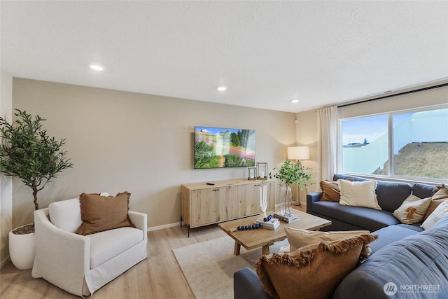 living room featuring light wood-type flooring, baseboards, and recessed lighting