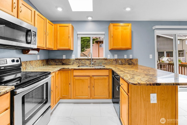 17421 73rd Ave NE, Arlington, WA 98223 - kitchen with stainless steel appliances, a sink, a peninsula, a skylight, and light stone counters