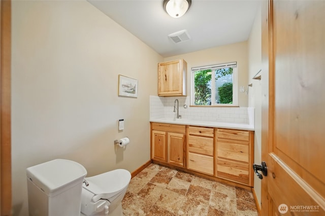 52 Buttonquail Ln, Walla Walla, WA 99362 - bathroom featuring toilet, backsplash, vanity, and baseboards