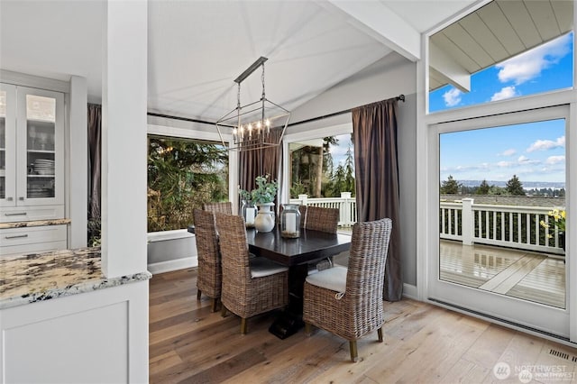 sunroom / solarium featuring a chandelier