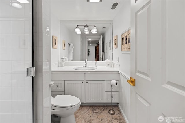 bathroom with toilet, a stall shower, vanity, and marble finish flooring
