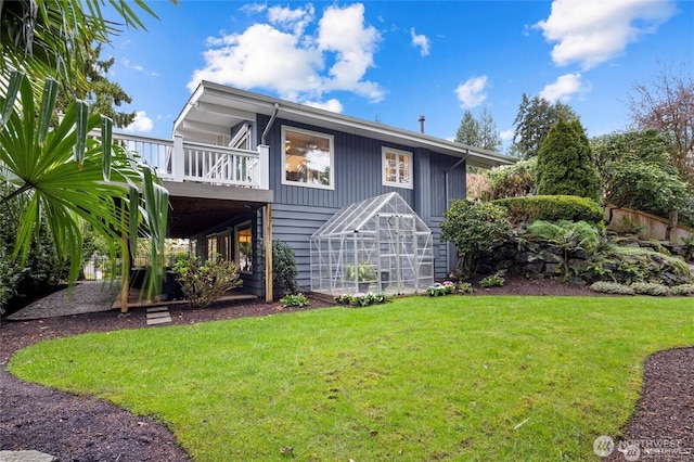 rear view of property with a wooden deck and a yard
