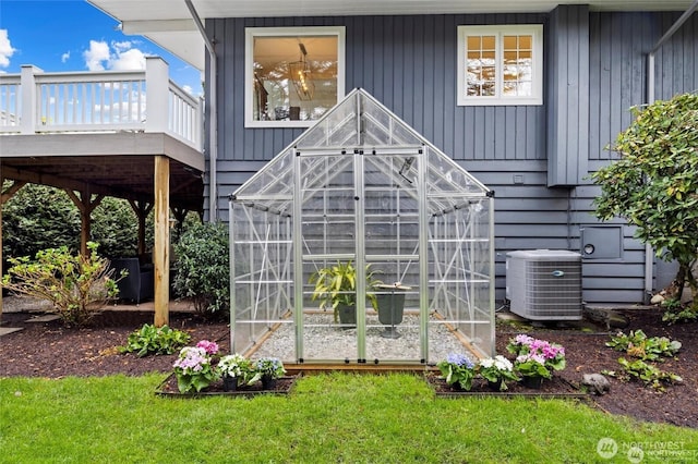 exterior view of central air condition unit and a greenhouse