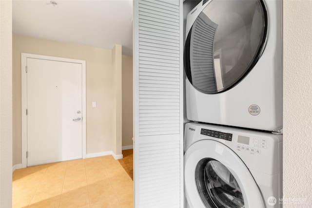 303 23rd Ave S Unit 308, Seattle, WA 98144 - clothes washing area featuring stacked washer / drying machine, light tile patterned floors, and baseboards