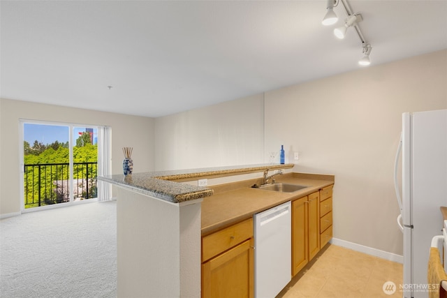 303 23rd Ave S Unit 308, Seattle, WA 98144 - kitchen featuring white appliances, a sink, a peninsula, rail lighting, and baseboards