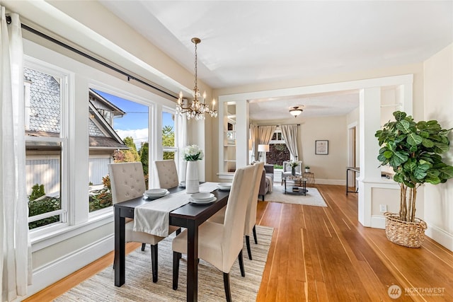 746 N 89th St, Seattle, WA 98103 - dining room featuring a chandelier, light wood-style floors, and baseboards