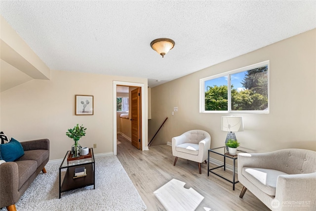 746 N 89th St, Seattle, WA 98103 - living room with light wood-style floors, baseboards, and a textured ceiling