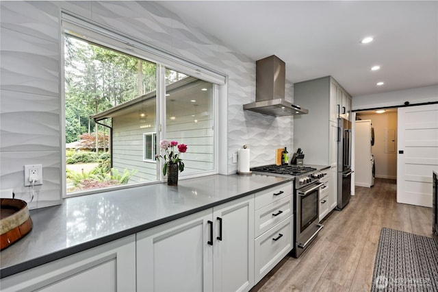 30 Hemlock Ct, Port Townsend, WA 98368 - kitchen with premium appliances, range hood, a barn door, recessed lighting, and light wood finished floors
