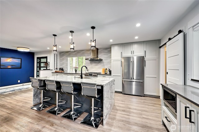 30 Hemlock Ct, Port Townsend, WA 98368 - kitchen featuring stainless steel appliances, light stone counters, light wood-type flooring, decorative backsplash, and island exhaust hood