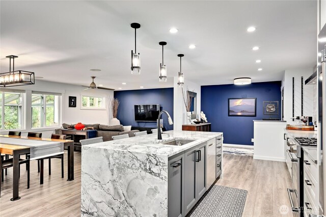 30 Hemlock Ct, Port Townsend, WA 98368 - kitchen featuring high end range, light wood-style flooring, light stone counters, an island with sink, and open floor plan