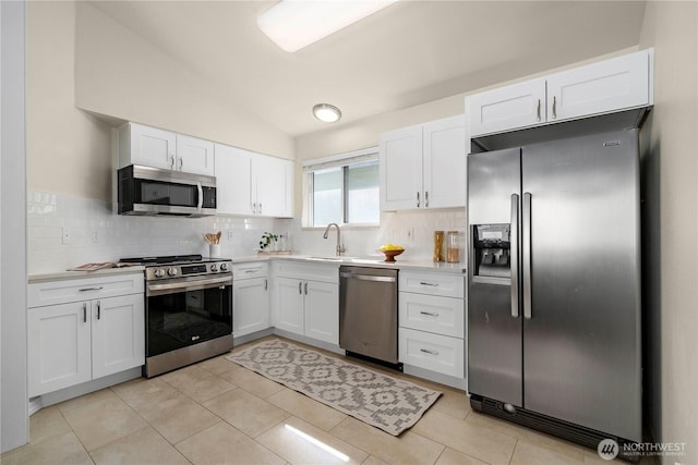 12408 1st Ave SW, Seattle, WA 98146 - kitchen with appliances with stainless steel finishes, white cabinetry, light countertops, backsplash, and vaulted ceiling