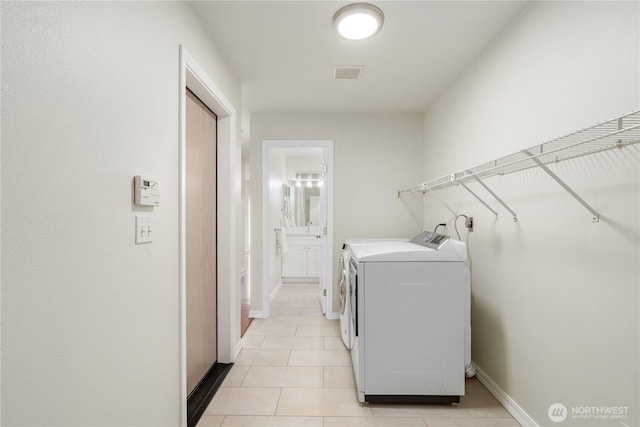 12408 1st Ave SW, Seattle, WA 98146 - washroom featuring separate washer and dryer, light tile patterned floors, and baseboards