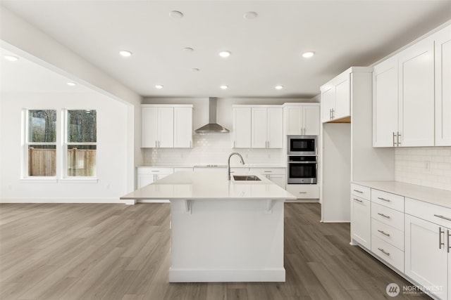 20263 145th St E Unit 857, Bonney Lake, WA 98391 - kitchen featuring stainless steel appliances, a sink, wall chimney range hood, light countertops, and decorative backsplash