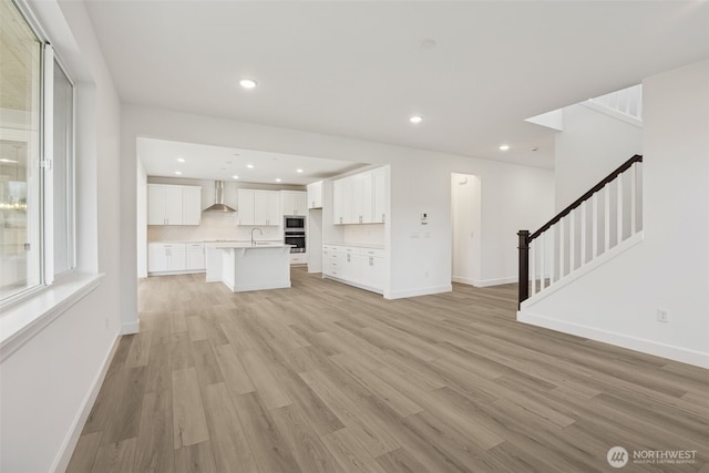 20263 145th St E Unit 857, Bonney Lake, WA 98391 - unfurnished living room with stairs, light wood-style flooring, recessed lighting, and baseboards