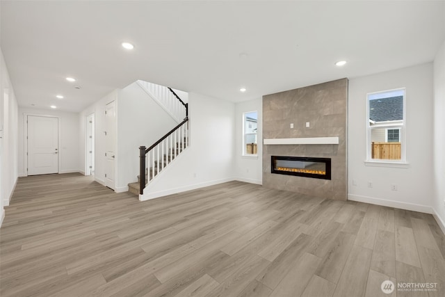 20263 145th St E Unit 857, Bonney Lake, WA 98391 - unfurnished living room featuring light wood finished floors, recessed lighting, stairway, baseboards, and a fireplace