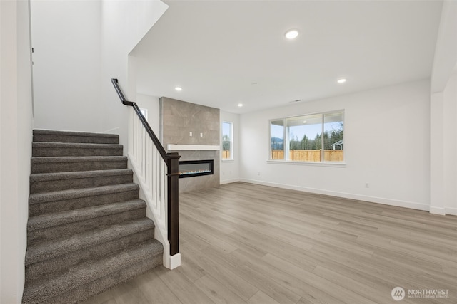 20263 145th St E Unit 857, Bonney Lake, WA 98391 - unfurnished living room with stairway, light wood-type flooring, a fireplace, baseboards, and recessed lighting