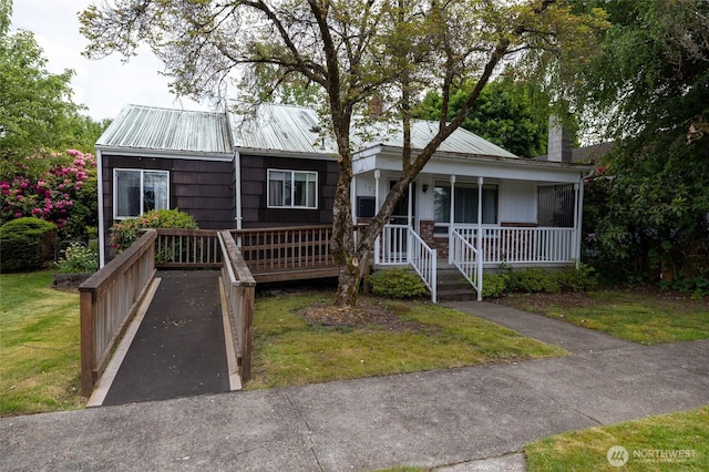 1122 G St, Centralia, WA 98531 - view of front of property with a porch, metal roof, a front yard, and a chimney